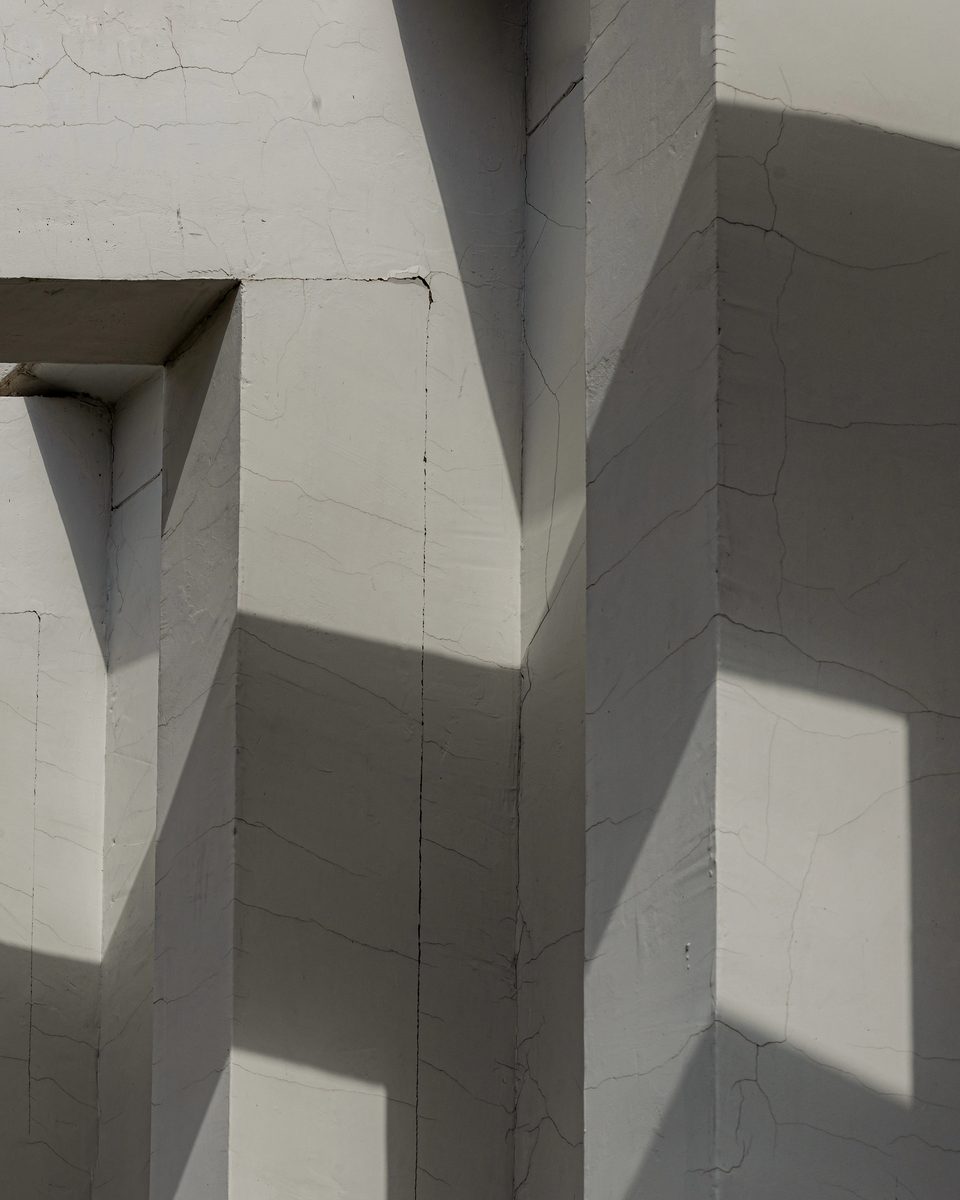 Sunlight falling across white cement columns, long shadows